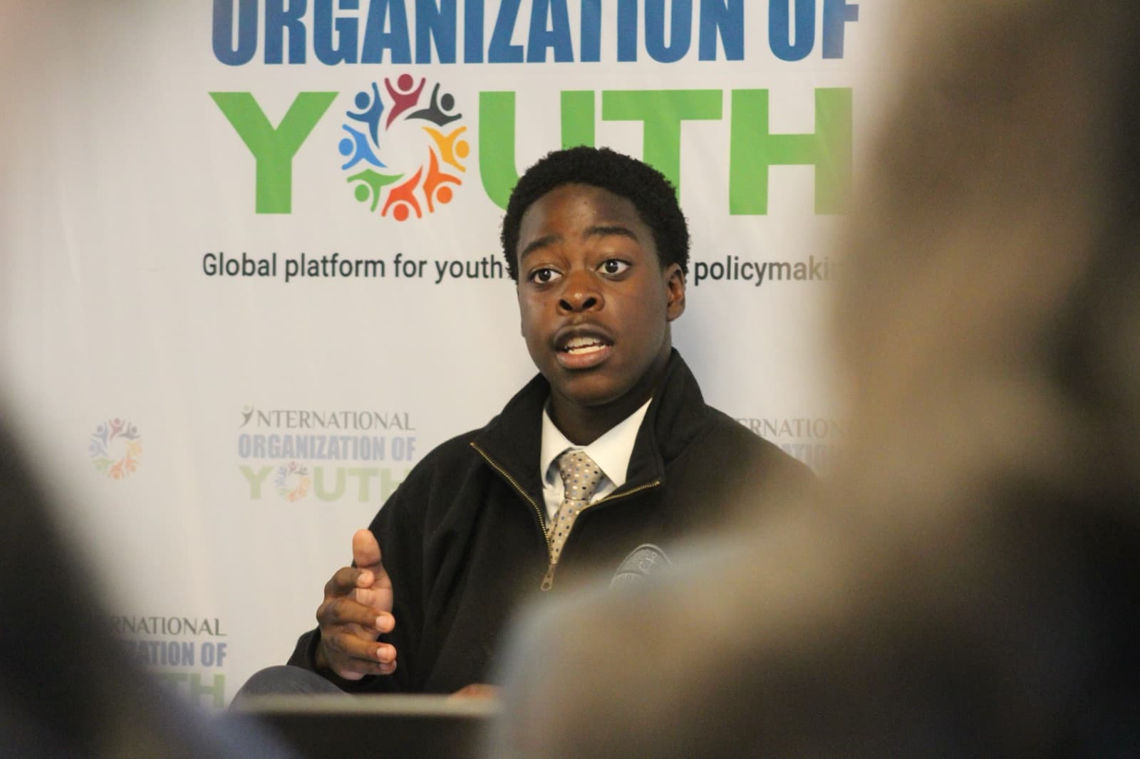 A young panelist speaking at a youth policy forum